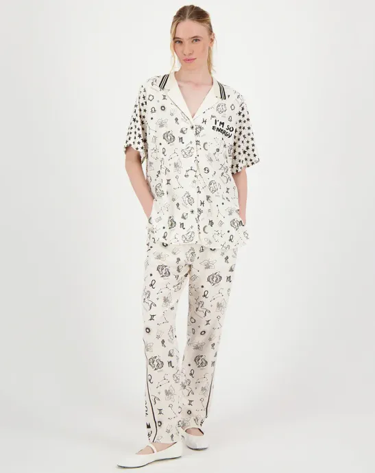 A woman is wearing a white jumpsuit and white shoes