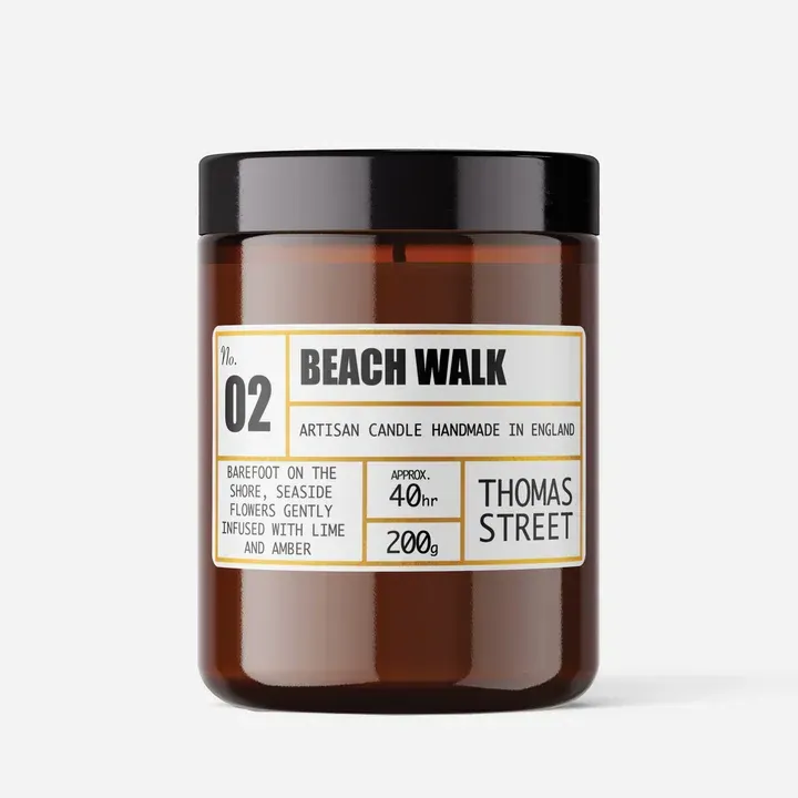 A candle in a jar with a label that says beach walk