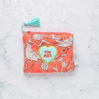 A pink purse with a heart on it that says `` you rock ''.