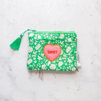 A green purse with a pink heart that says sweet on it