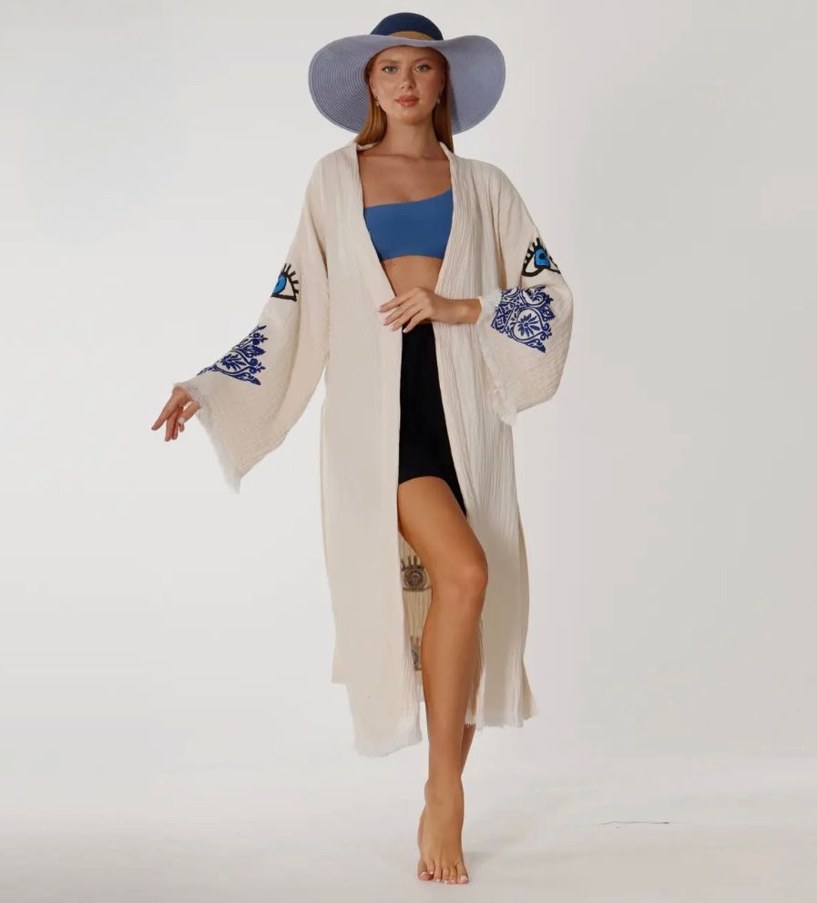A woman wearing a white kimono and a blue hat