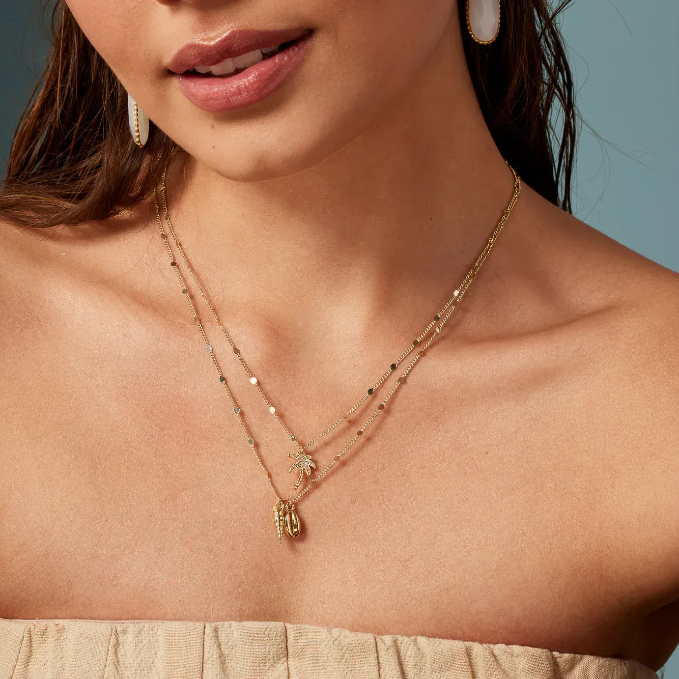 A close up of a woman wearing a gold necklace