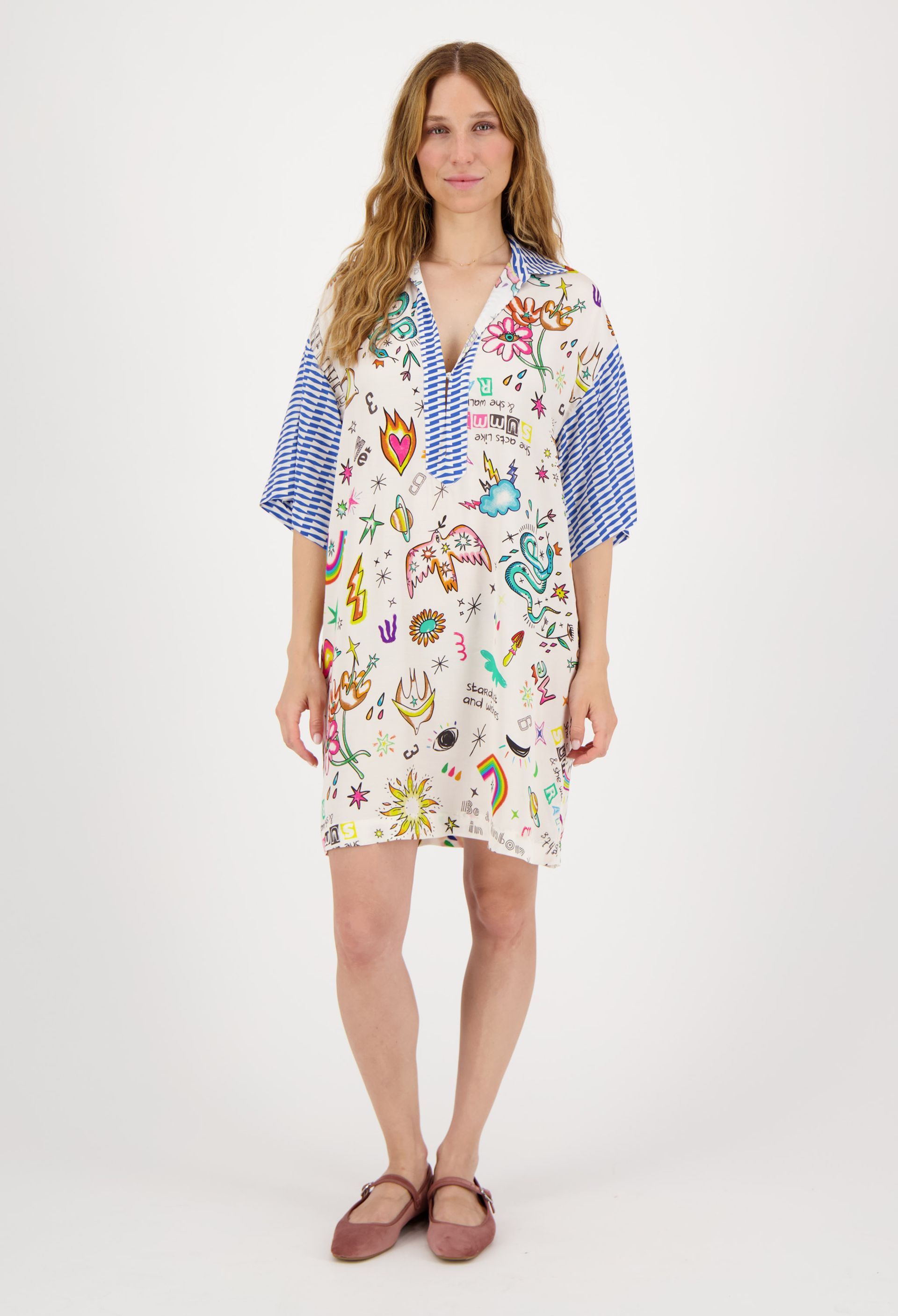 A woman is wearing a white dress with a colorful pattern on it.