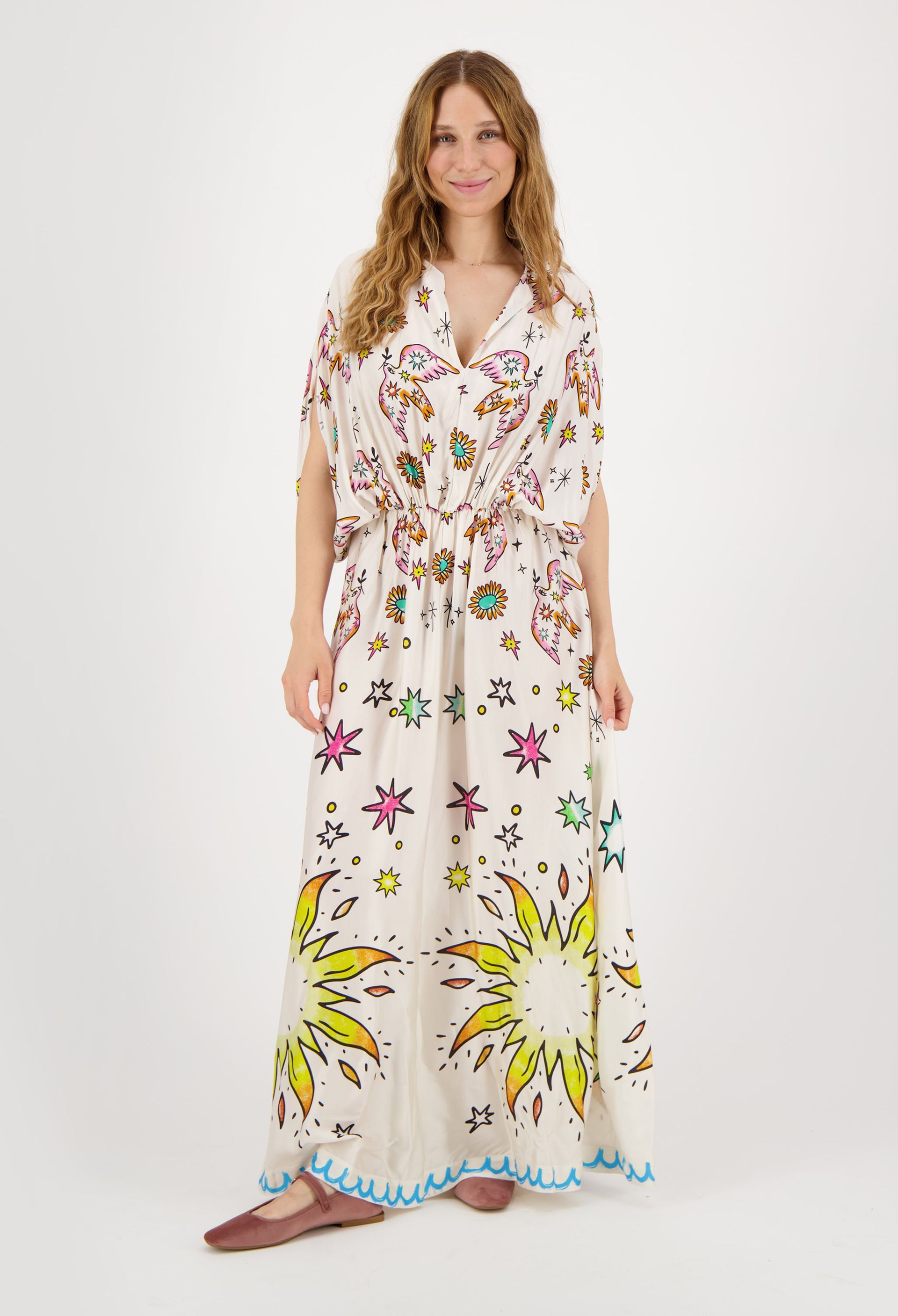 A woman is wearing a long white dress with flowers on it.