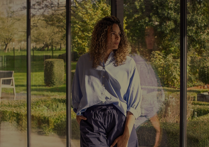 A close up of a woman wearing a necklace with a crescent moon pendant.