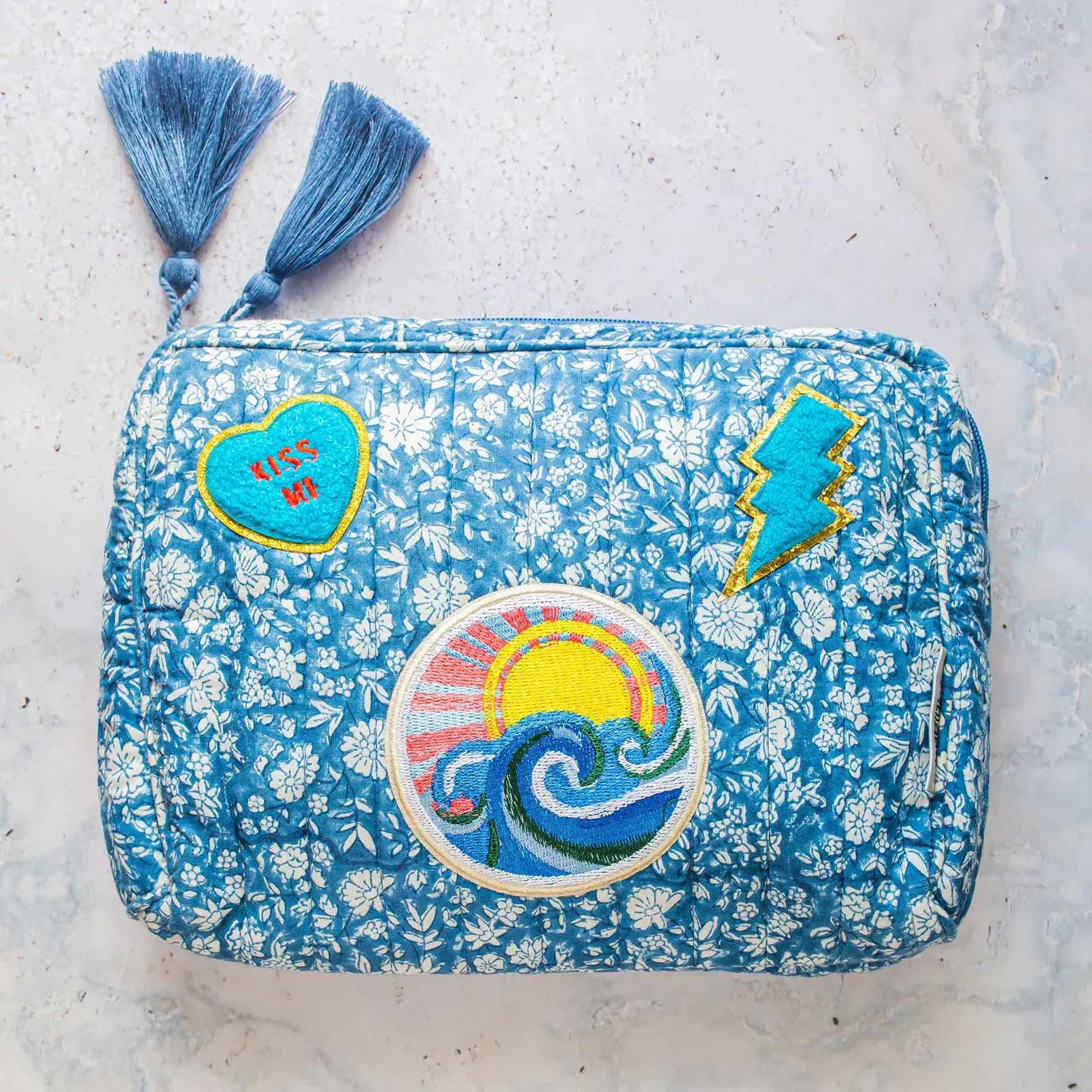 A blue purse with a lightning bolt embroidered on it