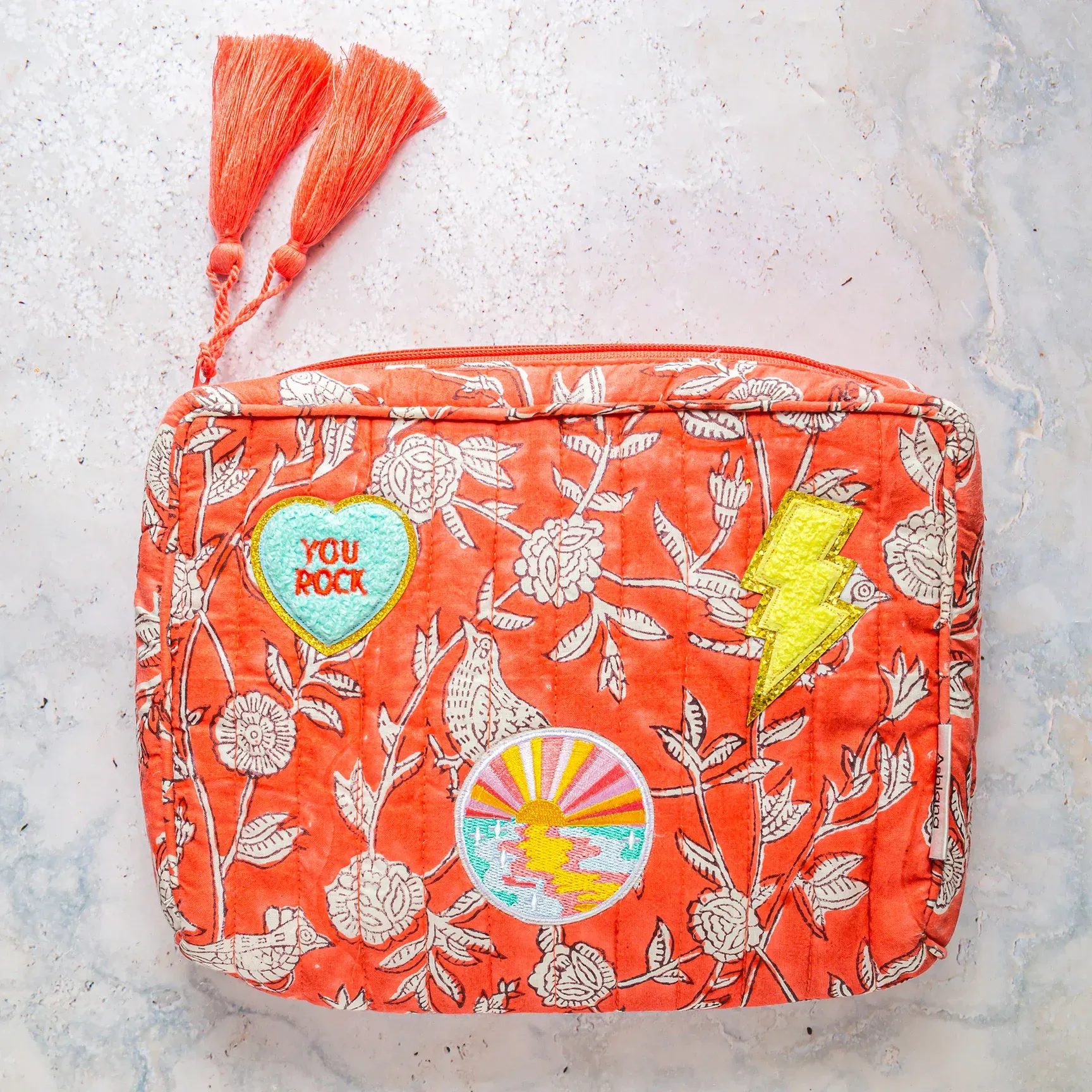 An orange purse with a heart that says you rock on it