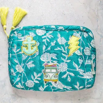 A green cosmetic bag with a floral pattern and a van on top of it.