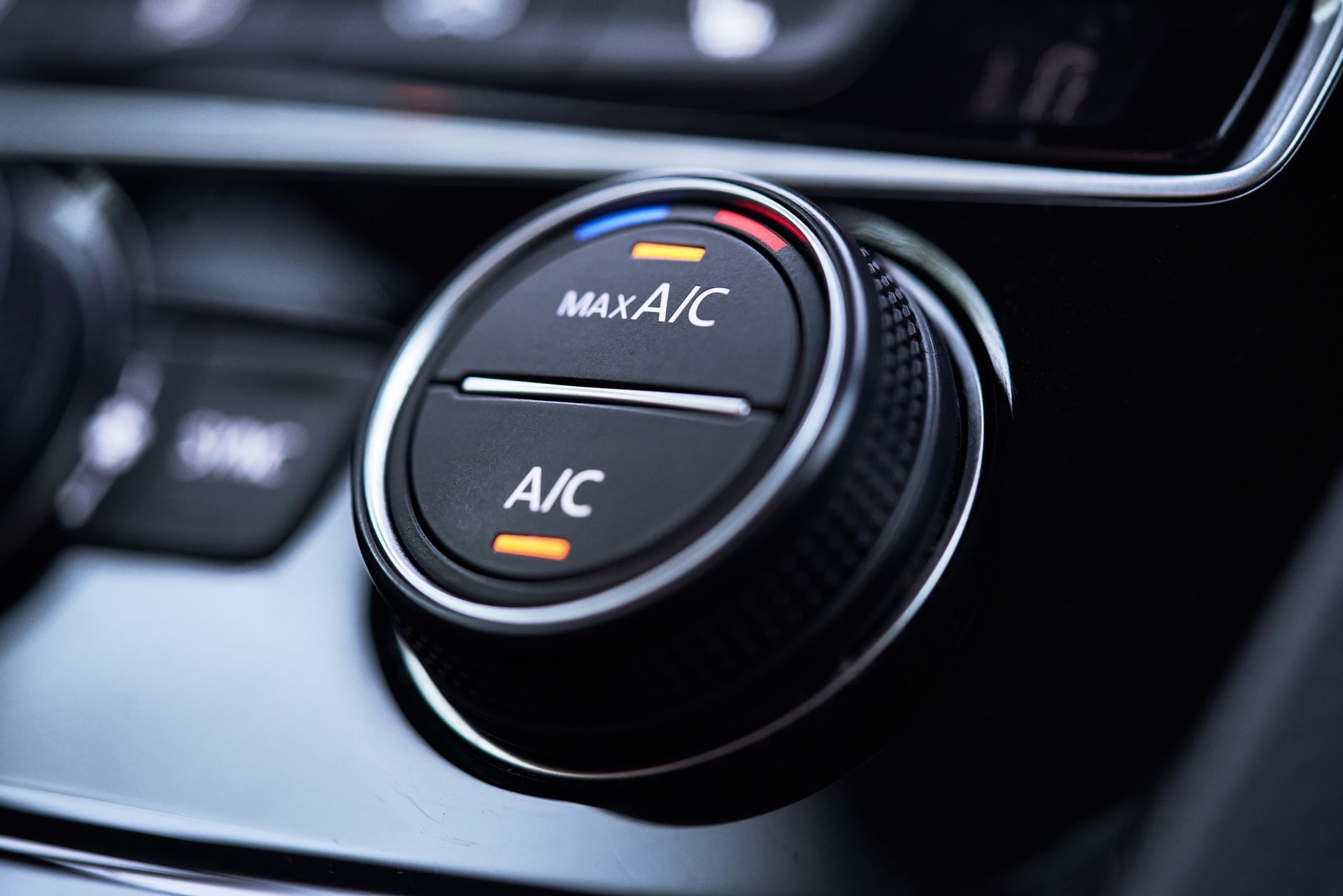 Close-up of a car climate control dial with A/C and MAX A/C settings in black and silver