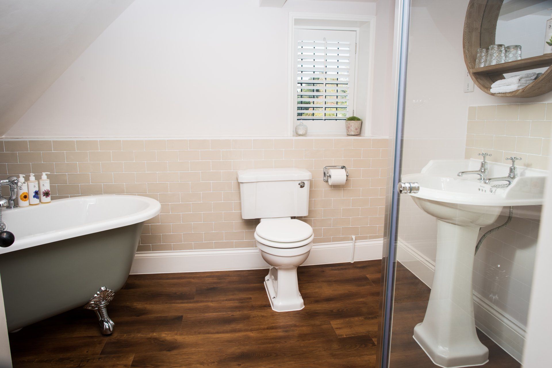 a bathroom with a tub , toilet , sink and mirror .