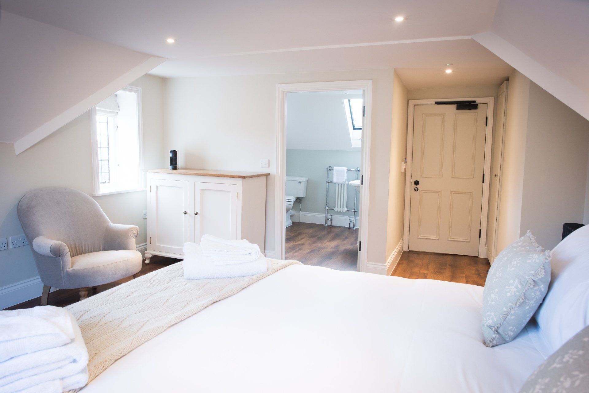 A bedroom with a bed , chair , and a bathroom.