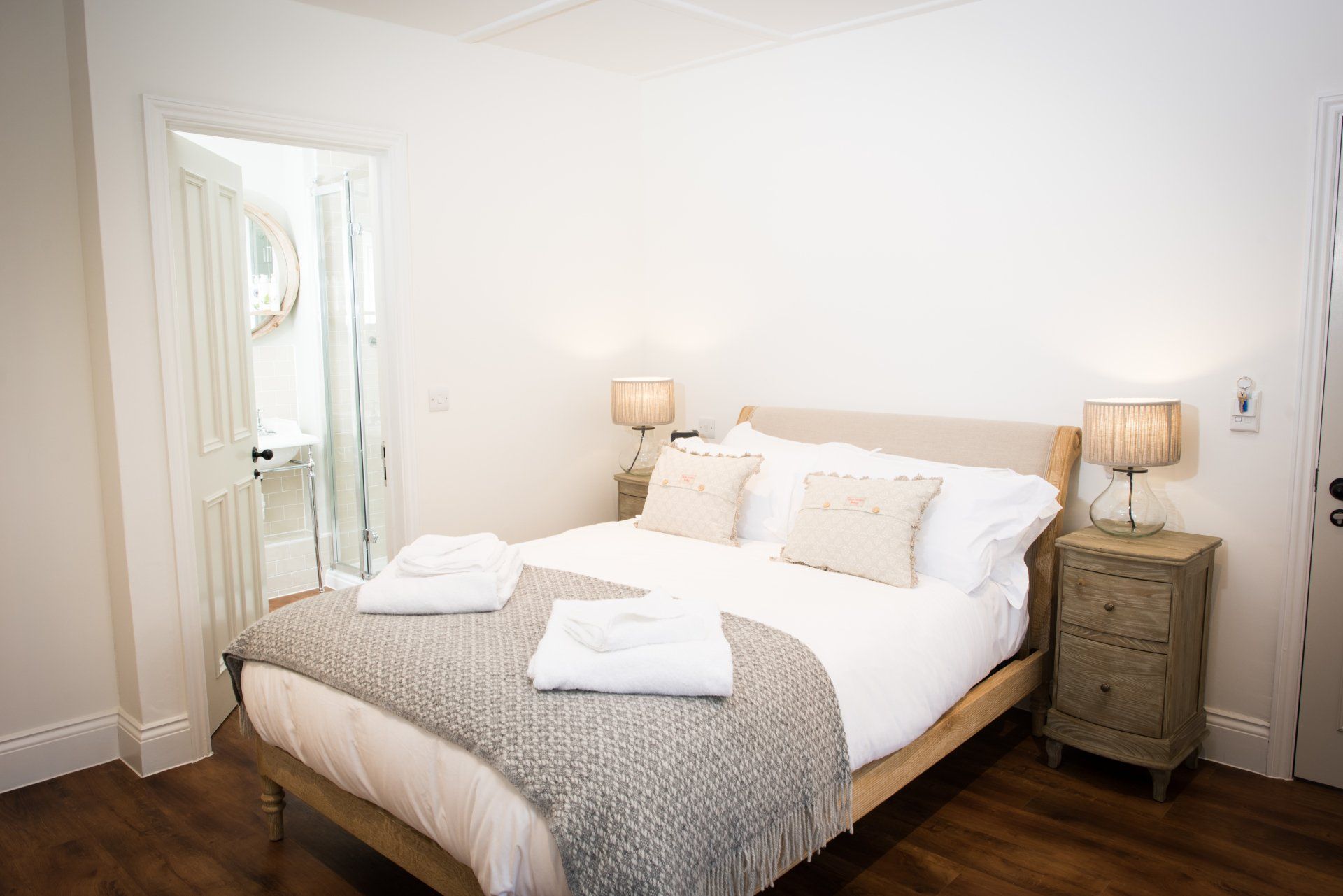 A bedroom with a bed , nightstand , and lamps.