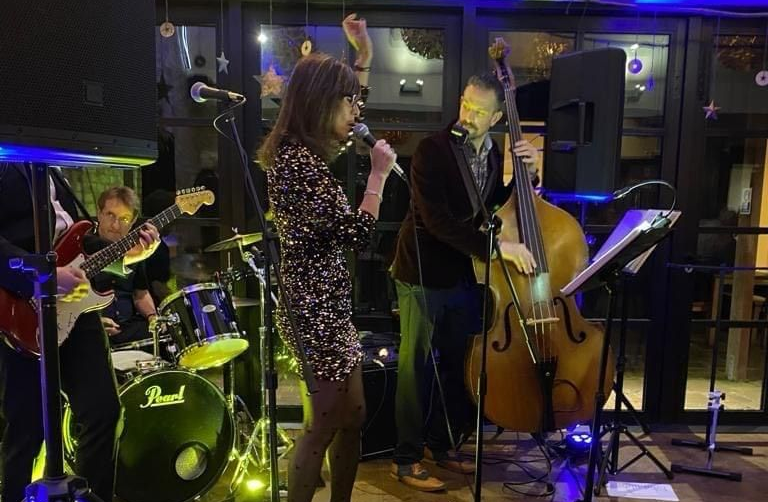 Stax of Soul performing on stage at a venue; singer with microphone, bassist, guitarist, drummer.