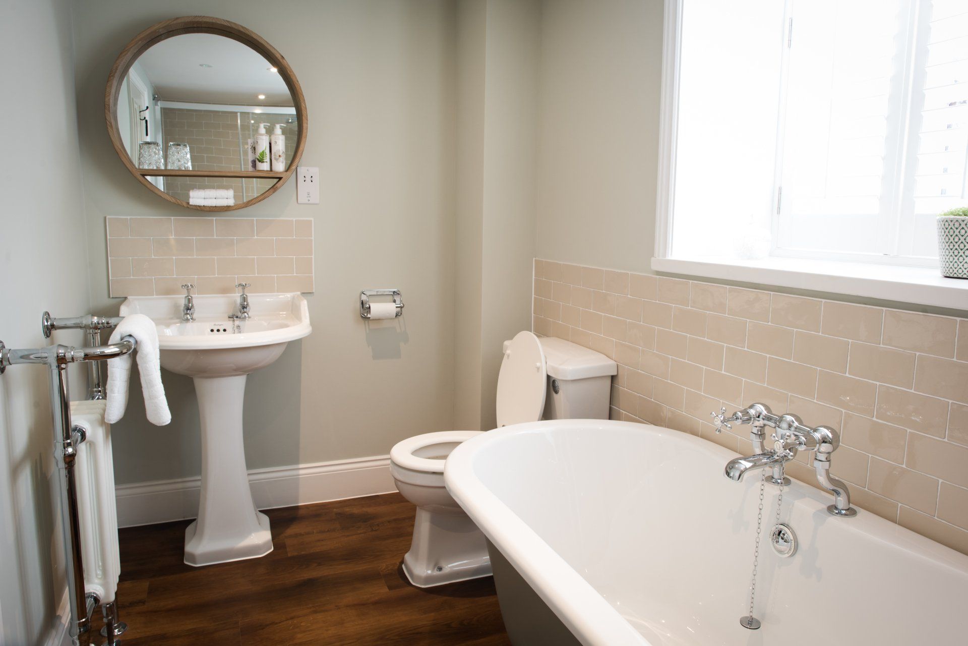 a bathroom with a bathtub , toilet , sink and mirror .