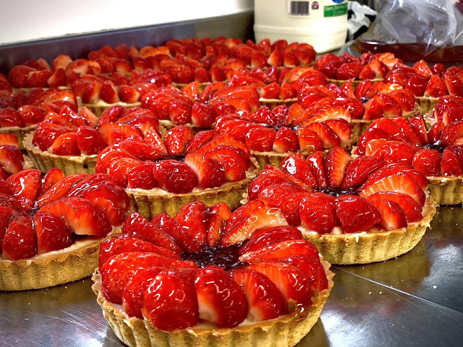 a bunch of strawberry tarts are sitting on a table .