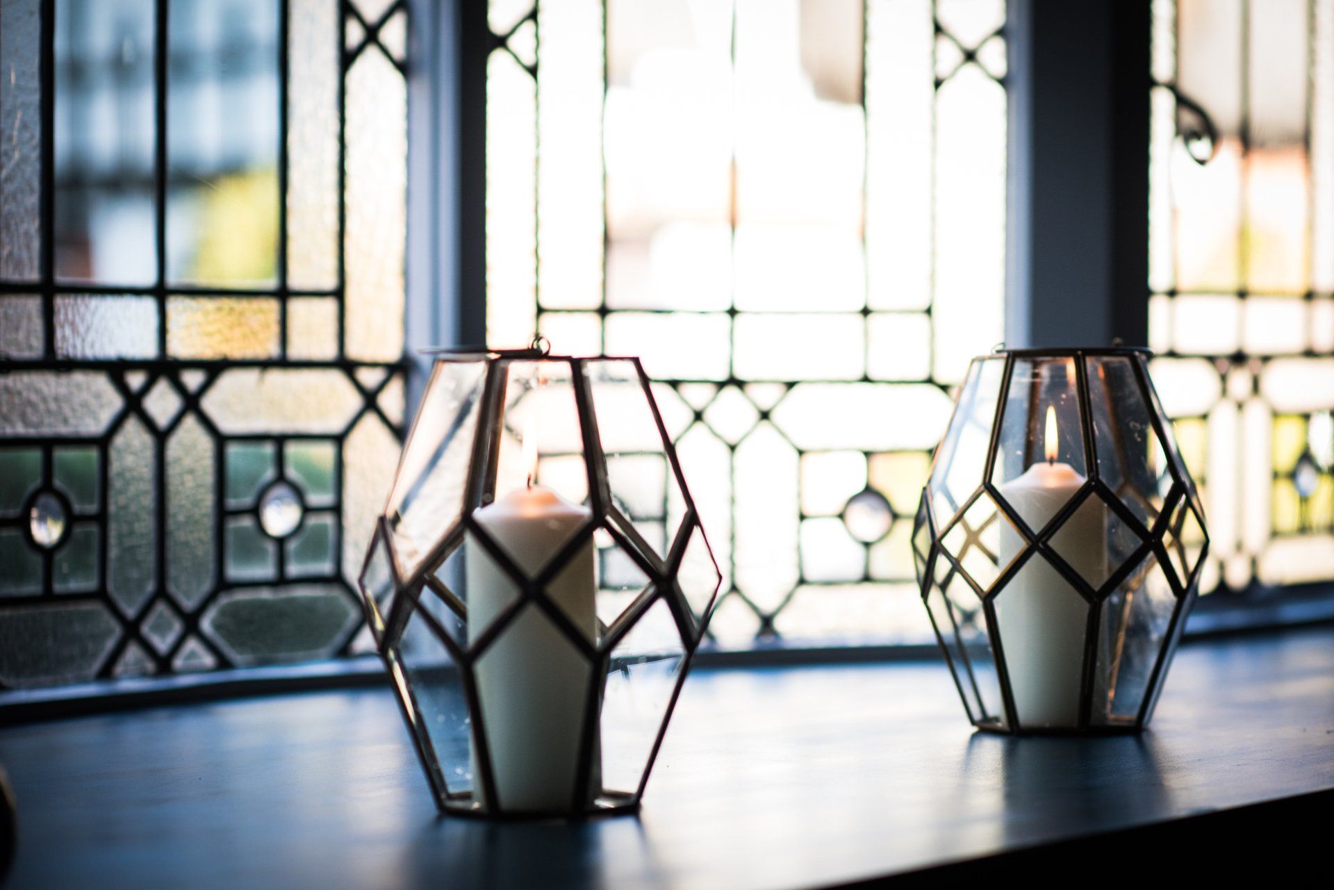 Three candles are sitting on a table in front of a window