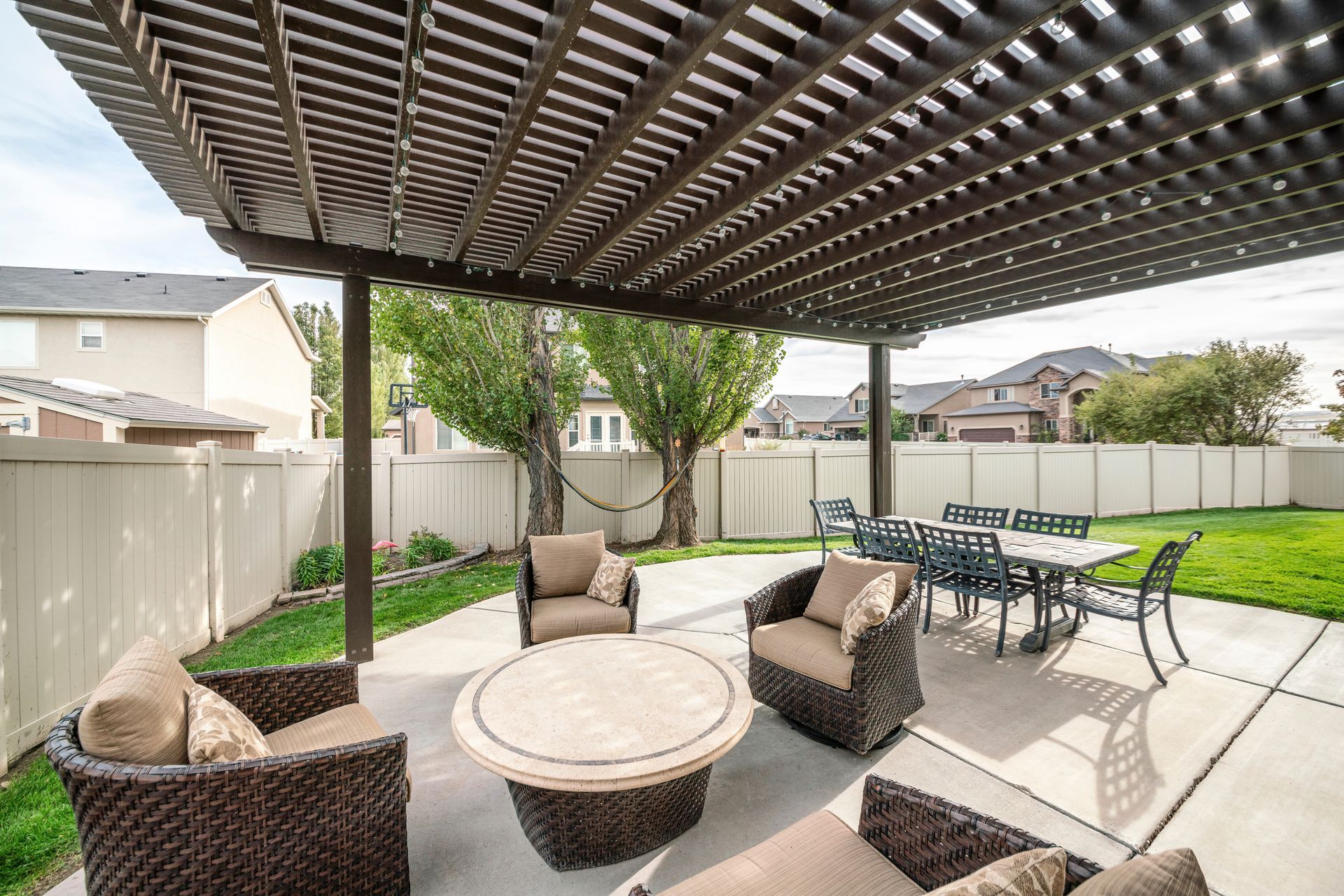 Un patio avec une table et des chaises sous une pergola.