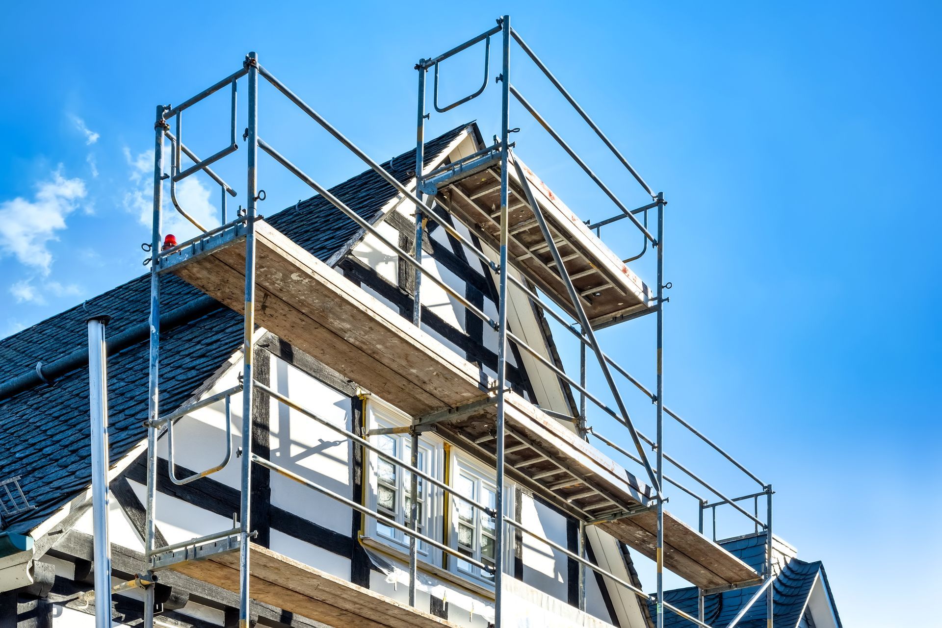 Une maison est en construction avec un échafaudage sur le côté.