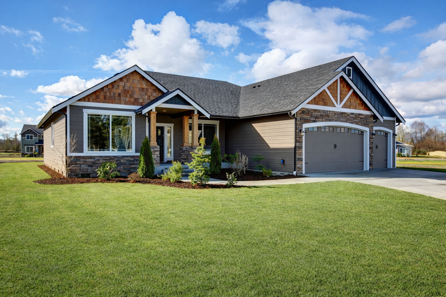 Brown and gray ranch-style house with three-car garage, green lawn, and blue sky.