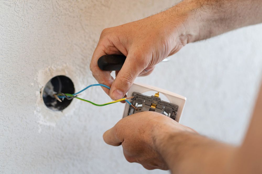 A Skilled Electrician Is Fixing A Light Switch