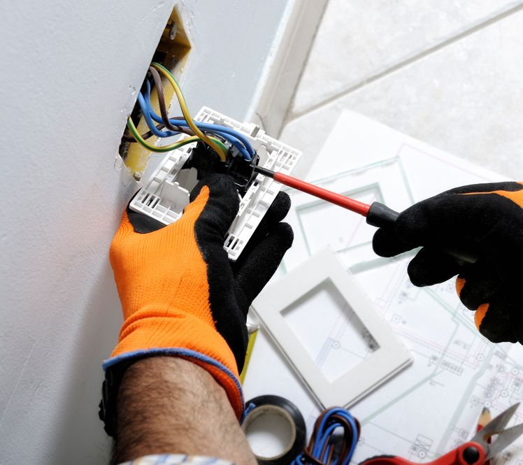 Electrician Installing a Light Switch Wearing Orange Gloves