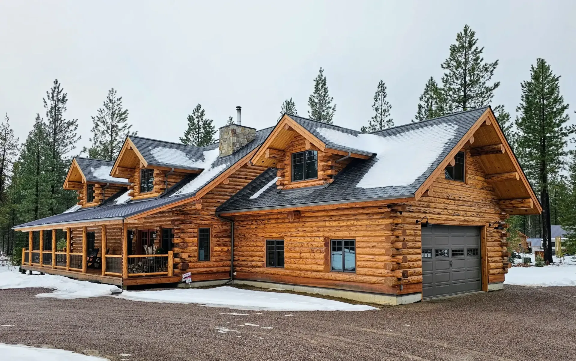 A log cabin with a green roof and a large deck