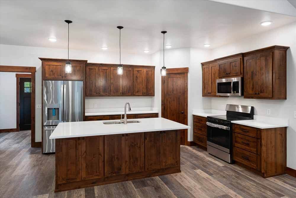 A kitchen with wooden cabinets, stainless steel appliances, and a large island.