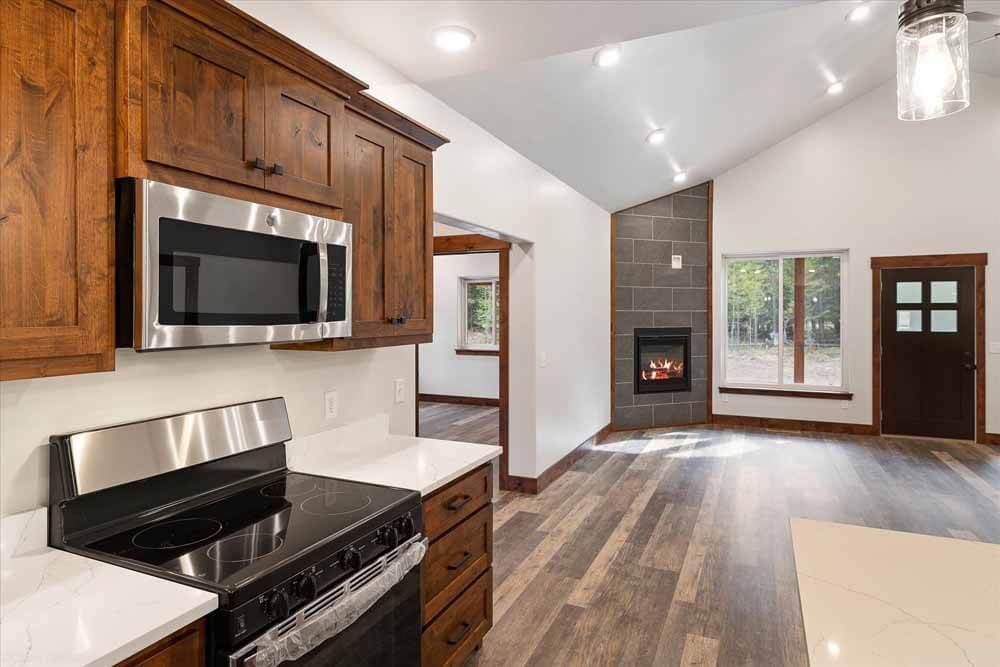 A kitchen with a stove, microwave, and fireplace.