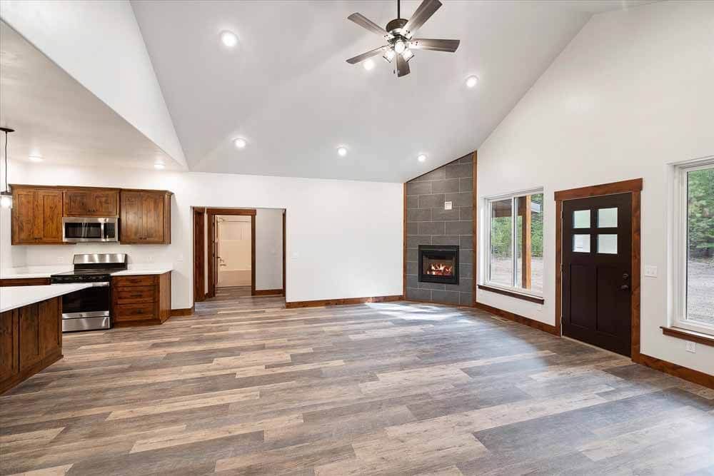 There is a ceiling fan in the living room and a fireplace in the kitchen.