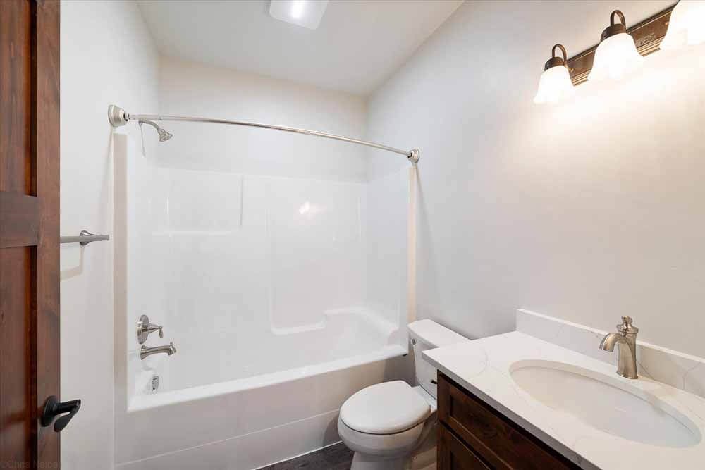 A bathroom with a toilet, sink, bathtub and shower.