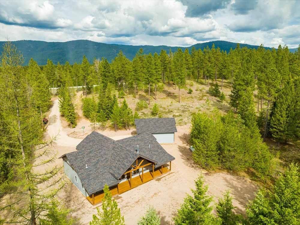 An aerial view of a house in the middle of a forest.