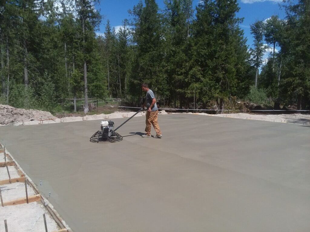 A man is using a machine to level a concrete surface.
