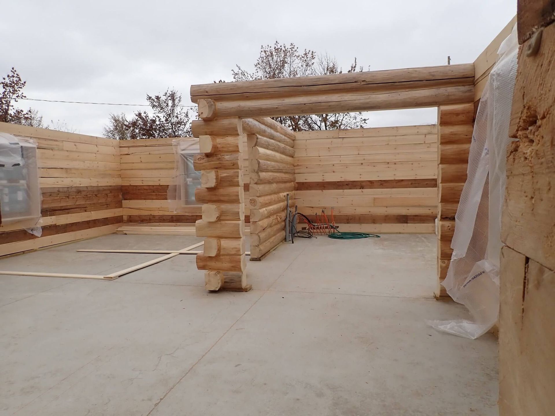 A large wooden structure is being built on a concrete floor.