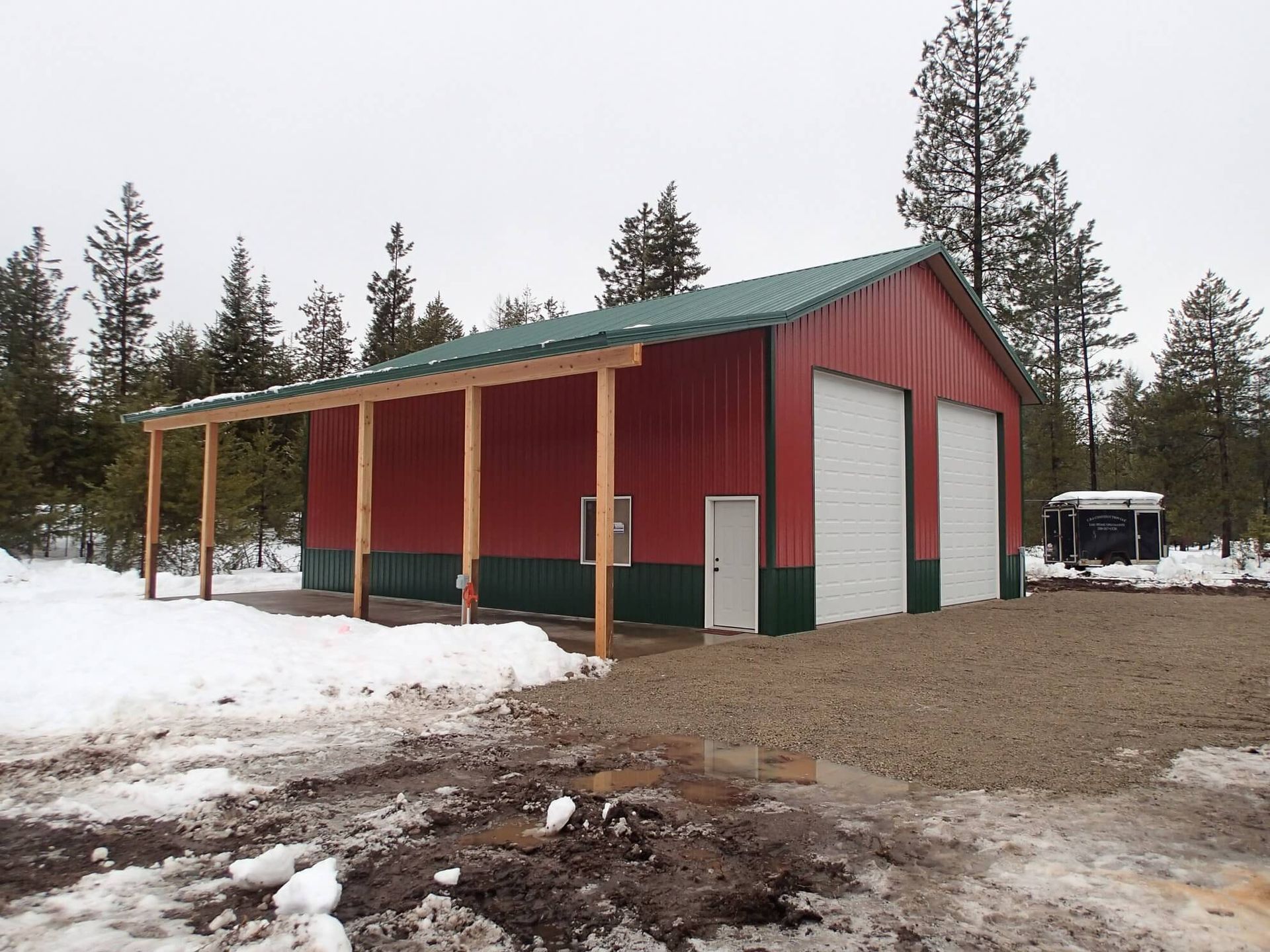 A red building with a green roof and white doors