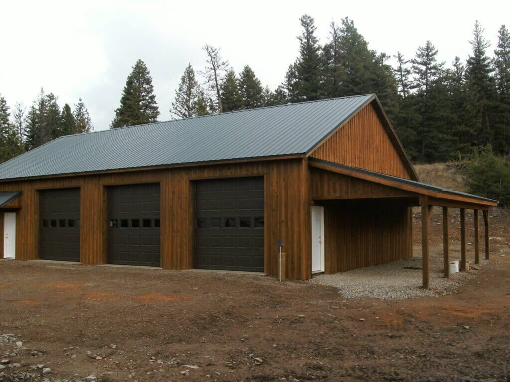 A large wooden garage with a metal roof