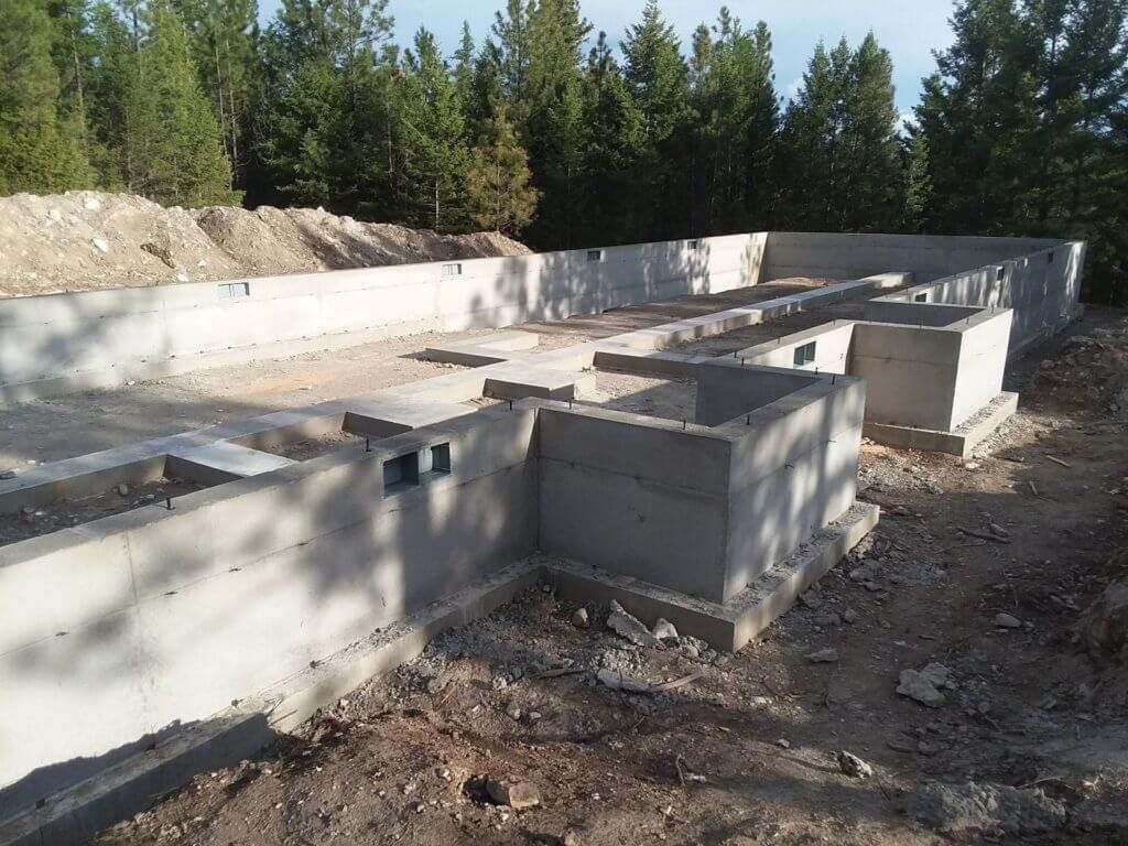 A concrete foundation is being built in the middle of a forest.