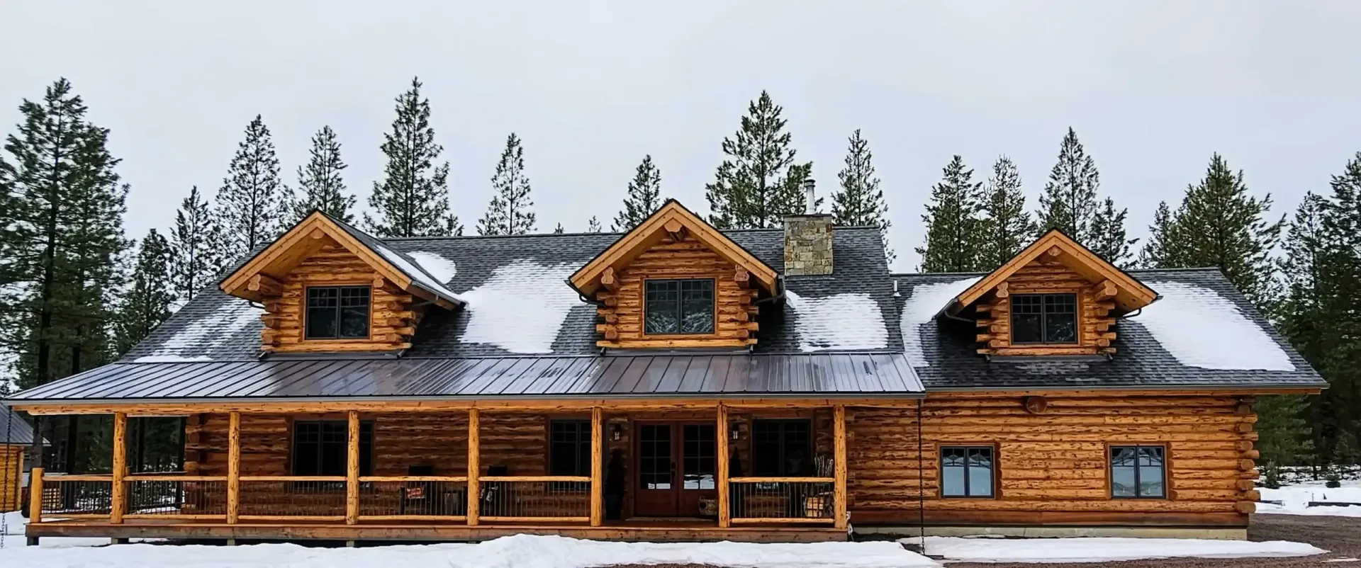 A large log cabin in the middle of a snowy forest.