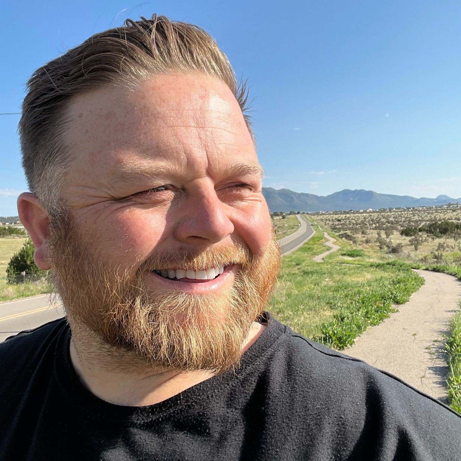 A man with a beard wearing a cowboy hat
