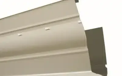 Tan-colored vinyl siding, with three horizontal ridges and small holes, against a white background.