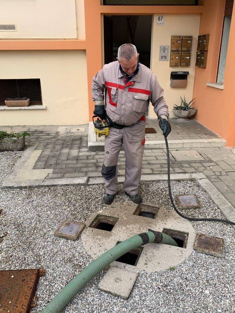 operatore effettua spurgo pozzo nero