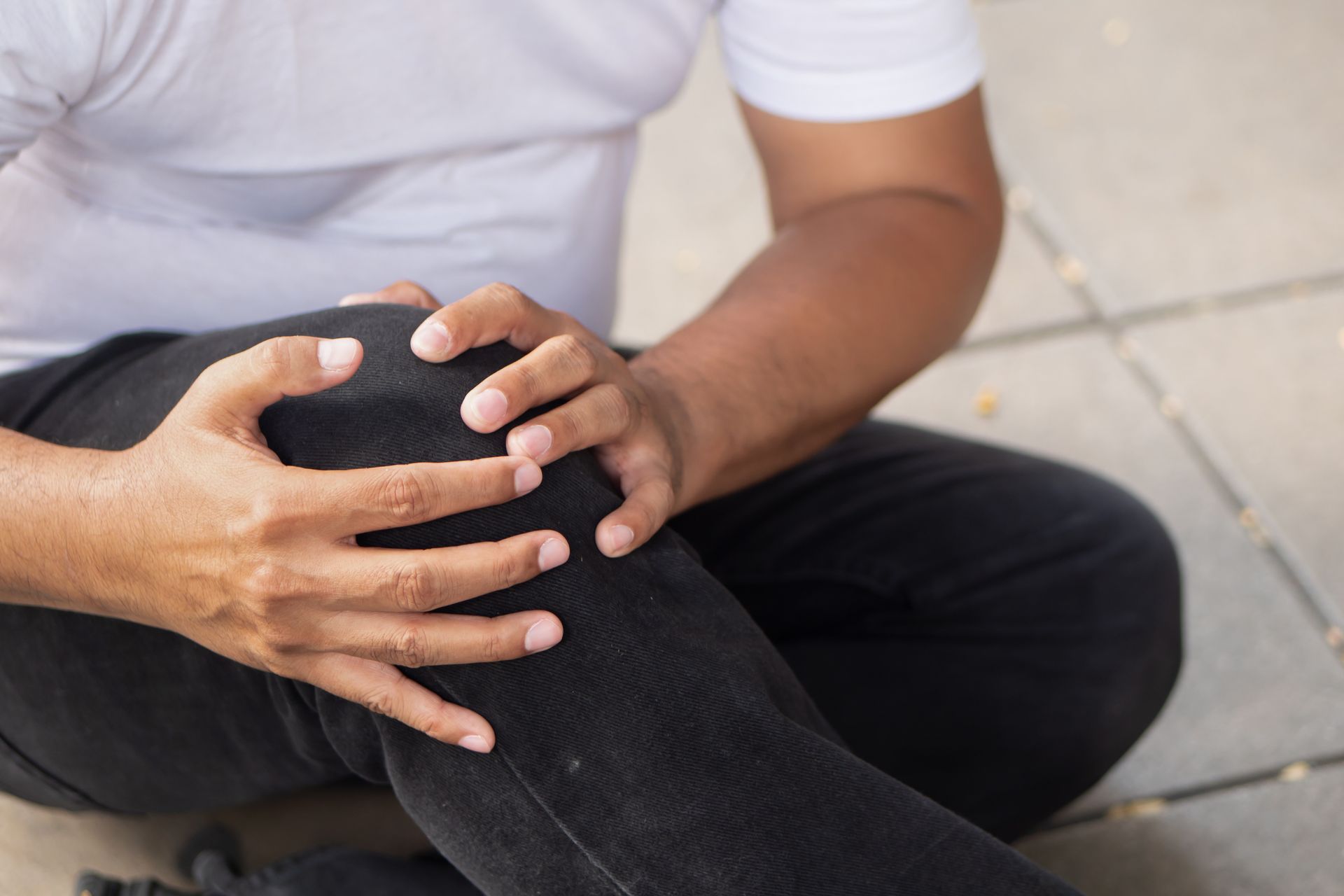 Man holding his hurt knee  after a slip and fall accident  