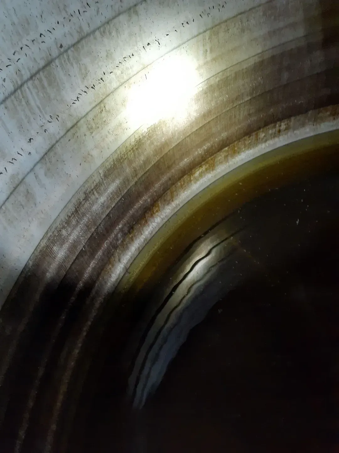 A Close Up of a Metal Pipe With a Light Shining Through It — Tink's Water Tank Cleaning in Harrington, NSW