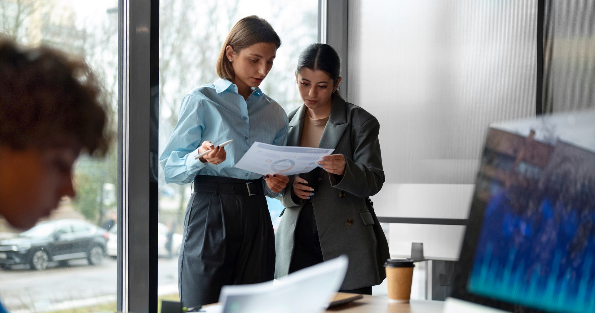 Person using laptop, hands on trackpad, another laptop on table.