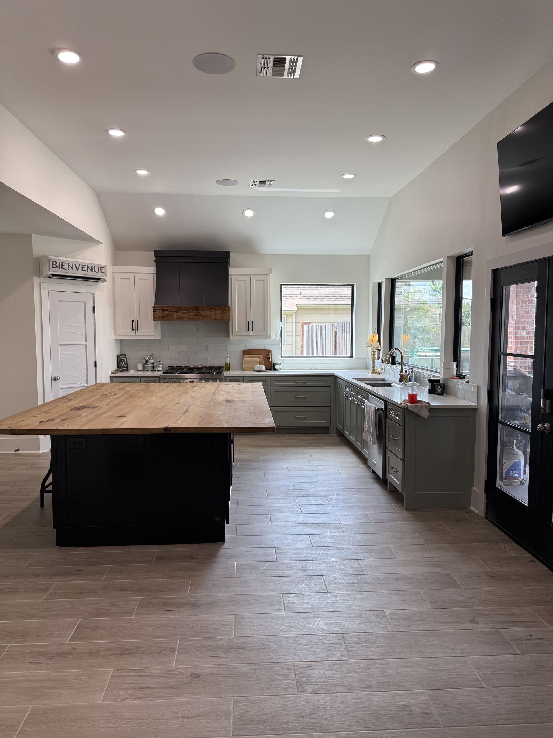 Kitchen with island and cabinetry, wood accents, tile flooring, and recessed lighting.