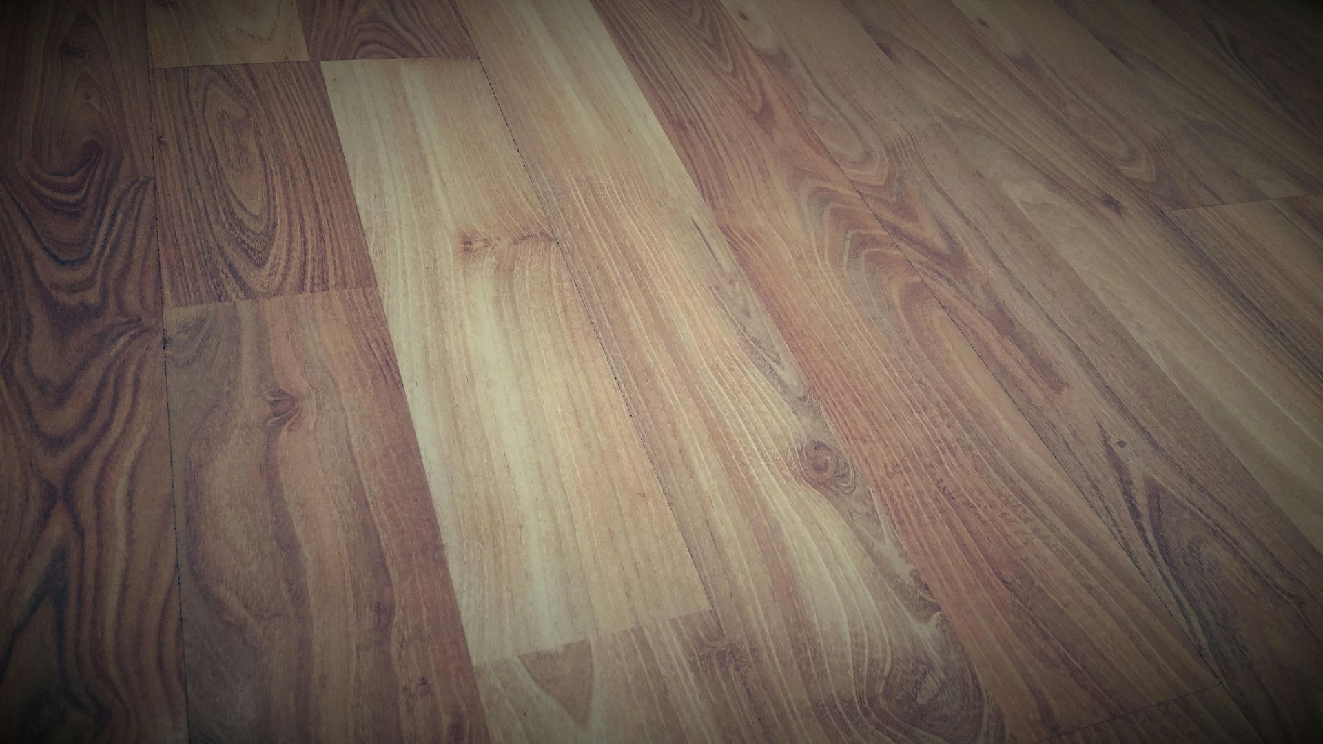 Wooden floorboards, varying shades of brown with wood grain patterns.