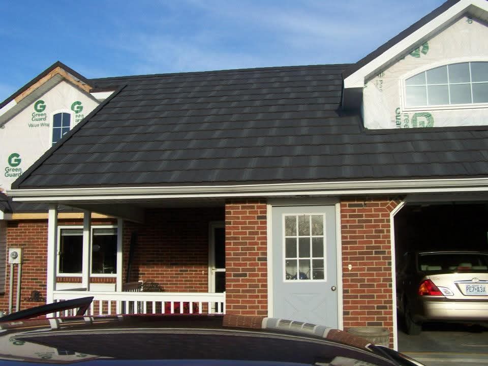 A brick house with a car parked in front of it
