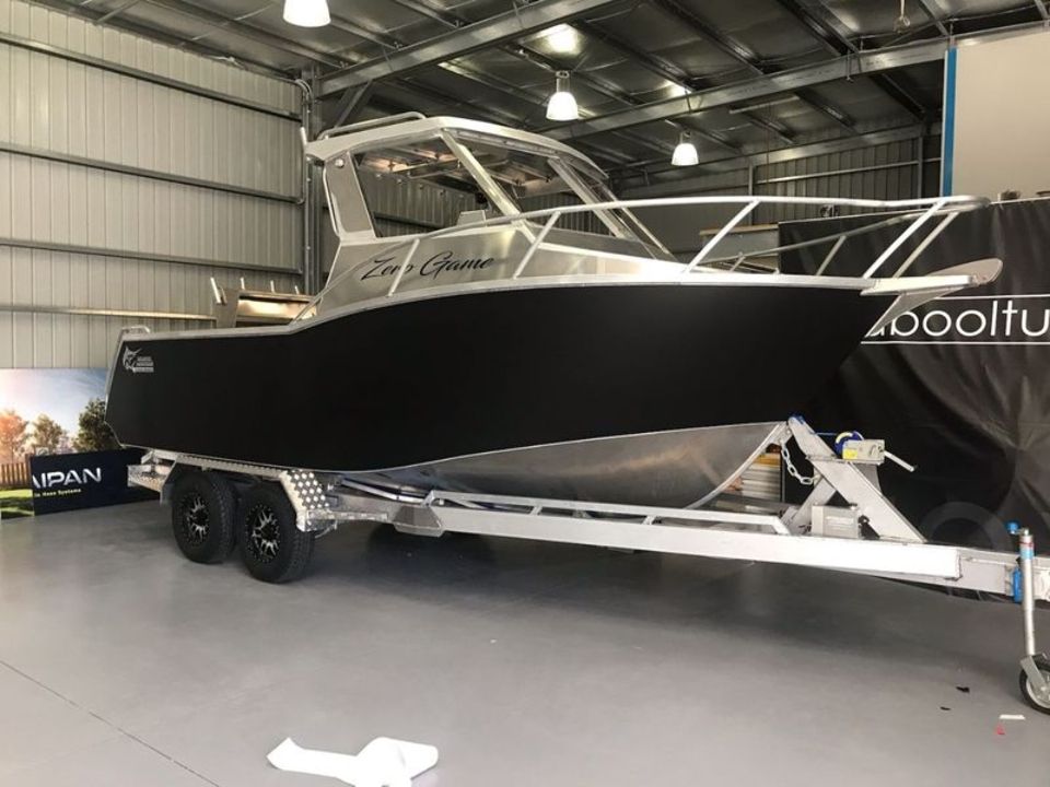 A boat is parked on a trailer in a warehouse.