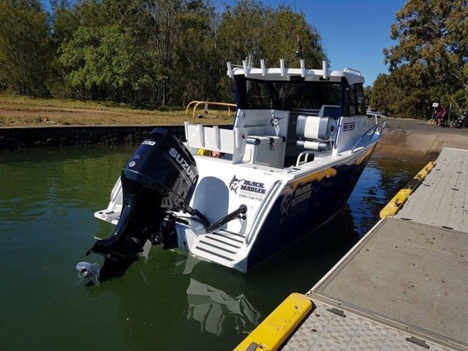 A boat with a suzuki outboard motor is docked at a dock