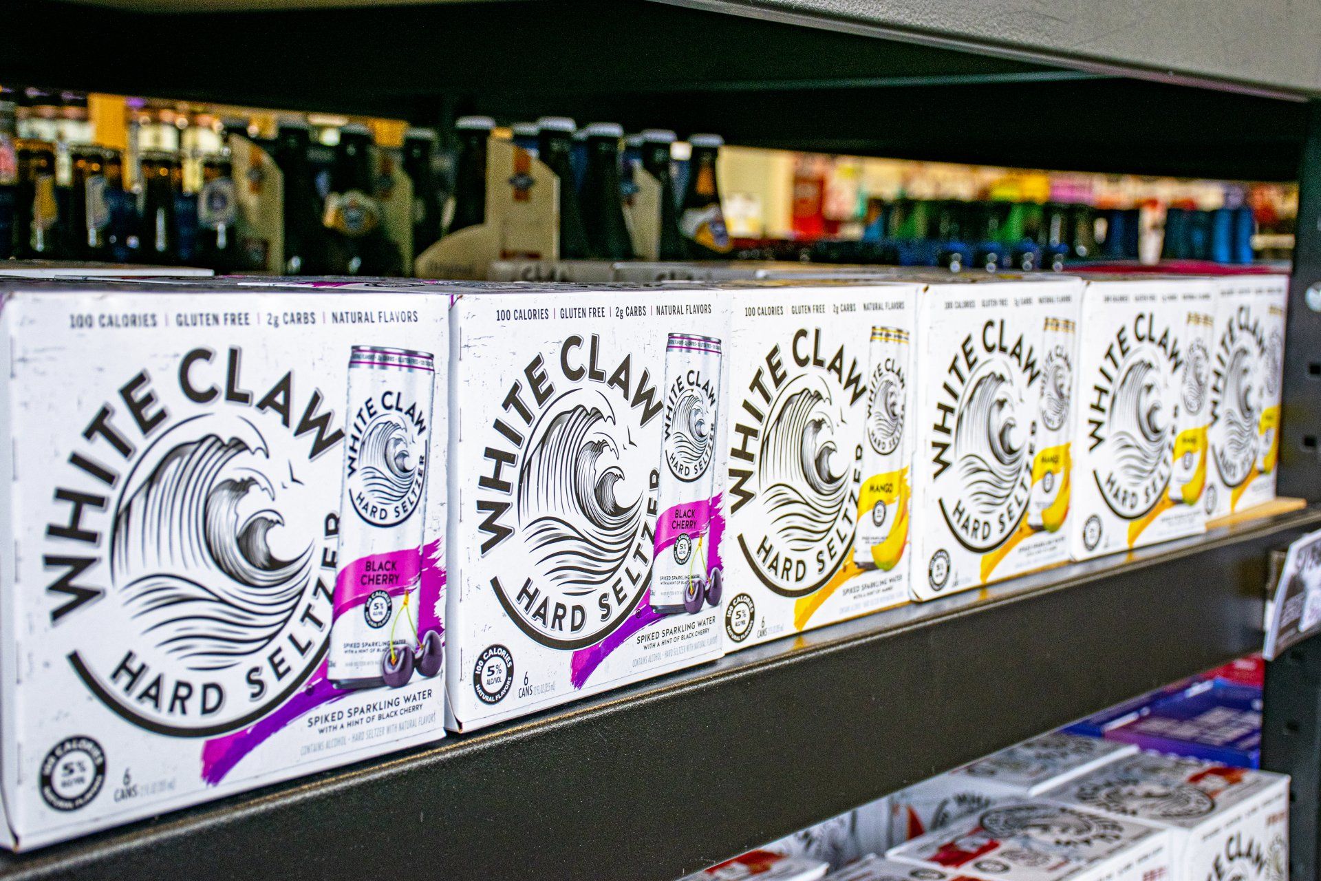 Boxes of White Claw hard seltzer on a store shelf.