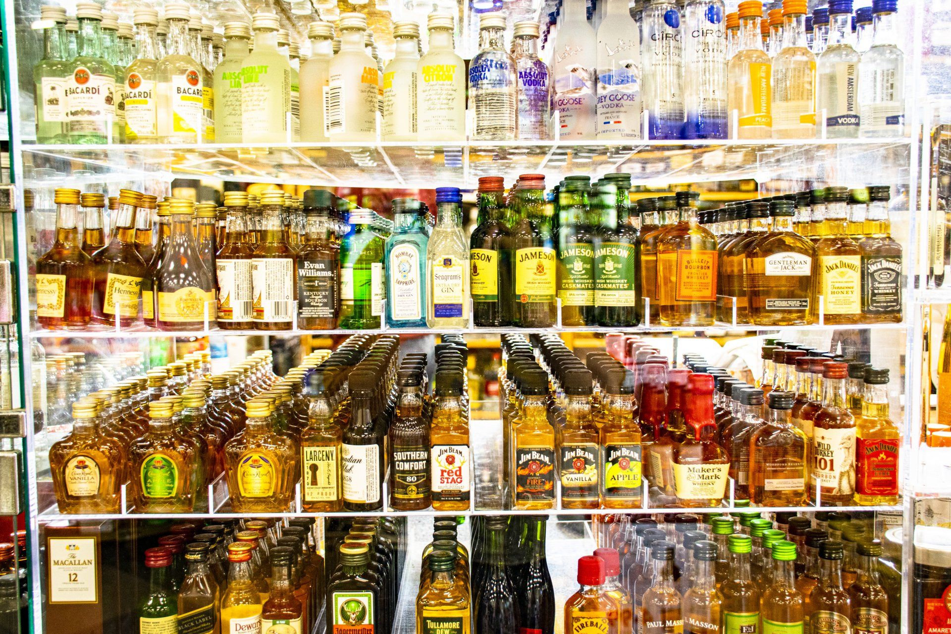 Shelves of liquor bottles in a store, displaying various brands and colors.